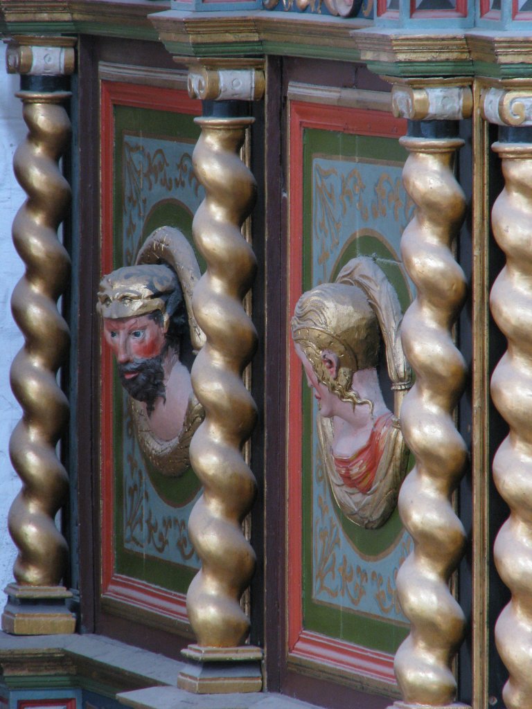 Twee Portretmedaillons op zijkant Balustrade, links van het Rugpositief