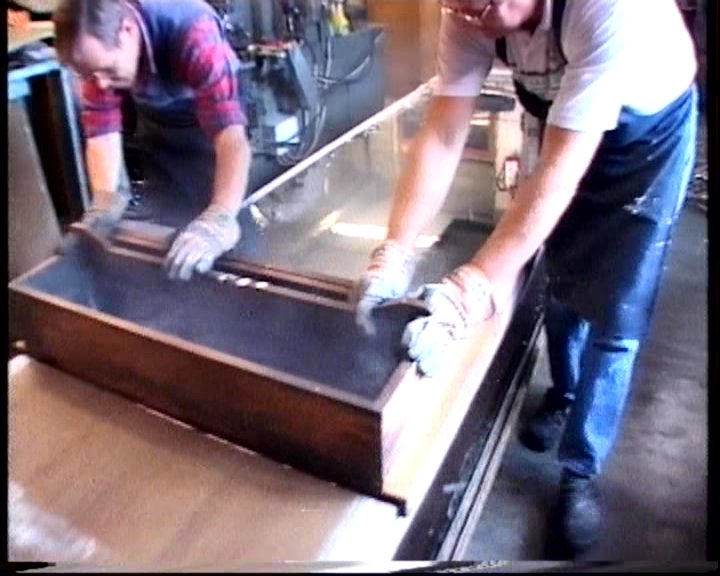 De trog met gesmolten orgelmetaal wordt over de gietbank uitgegoten tot een vlakke plaat